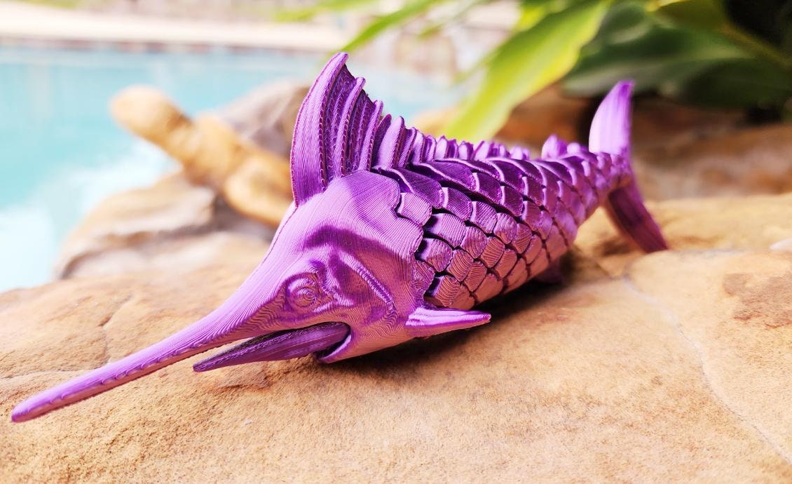 Articulated Marlin with its displaying plaque. Fidget toy, sensory toy.